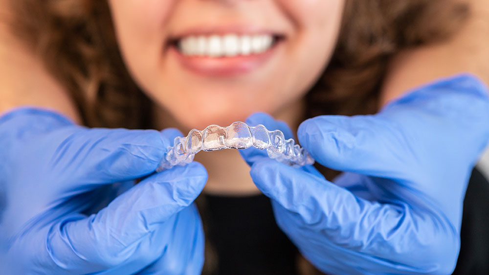 woman holding Invisalign tray